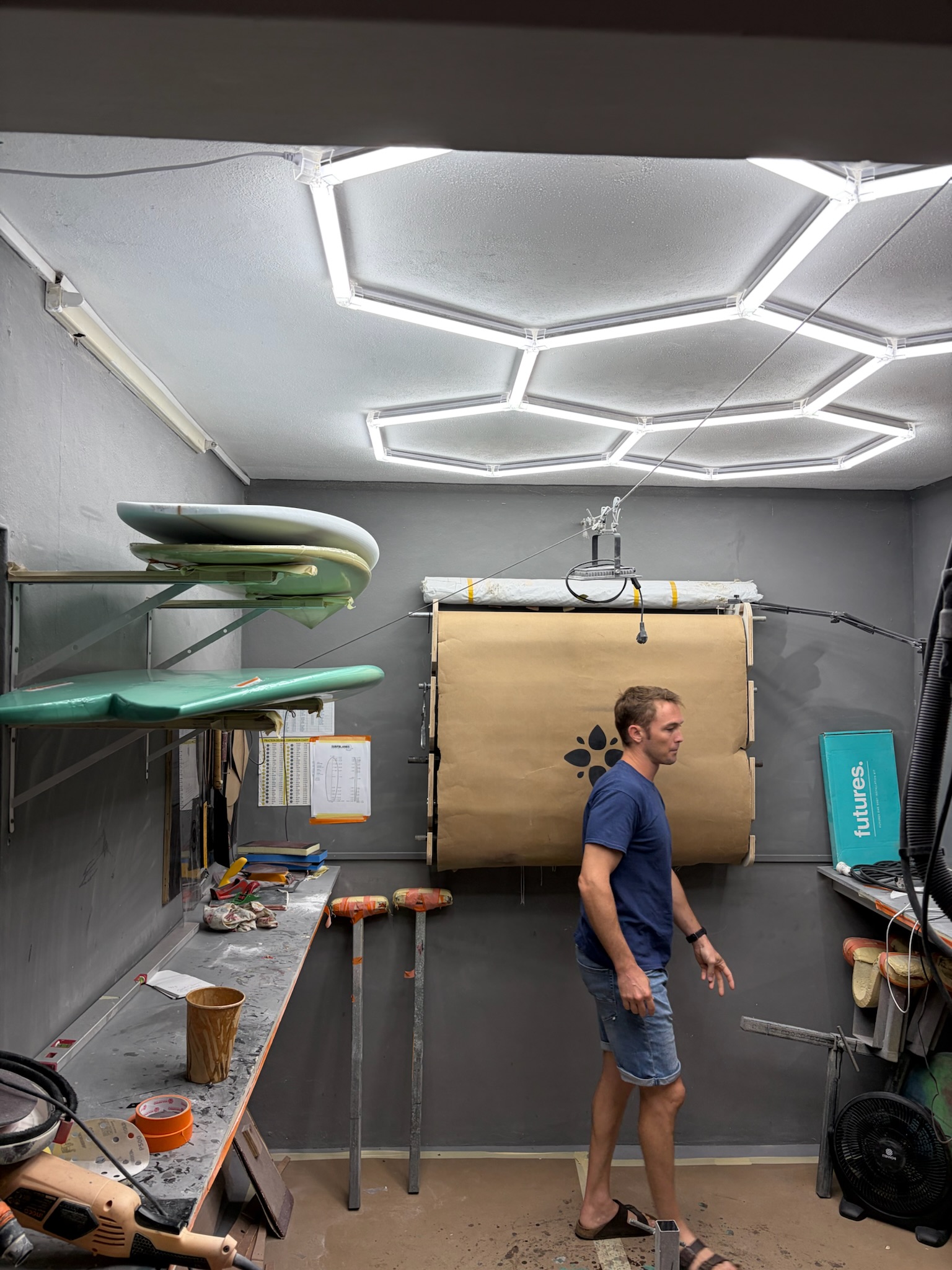 A shaper crossing the bay, drying racks and tools along the wall