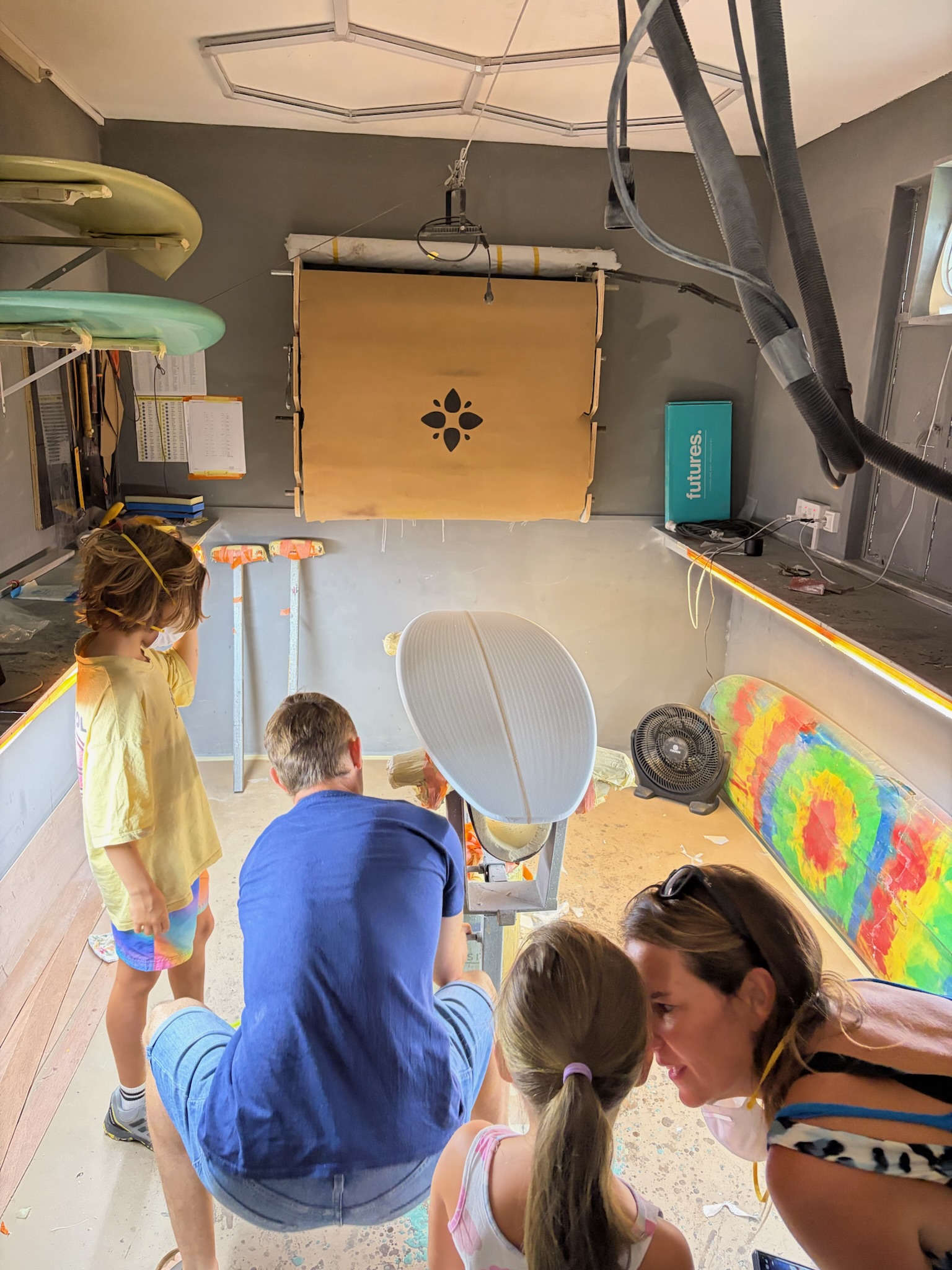 The crew gathered around the stand mid-session, a tie-dye board against the wall