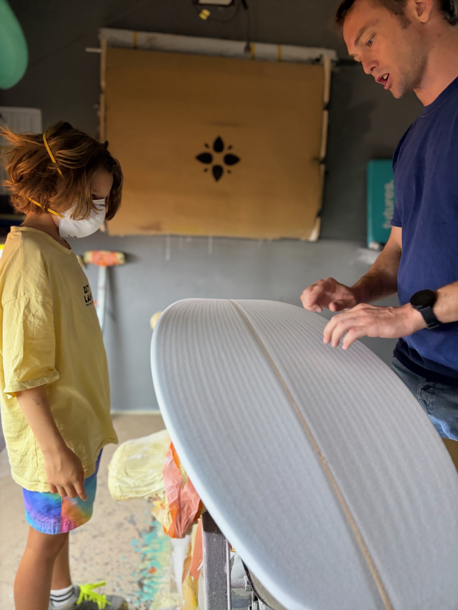 One of the shapers walking Noah through what comes off the board next