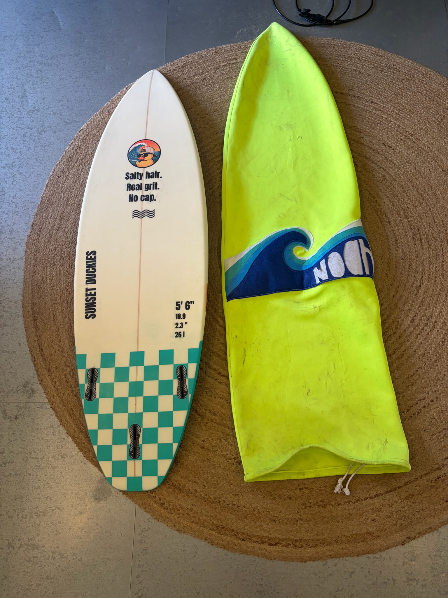 The finished board laid on a round jute rug next to Noah's yellow board sock