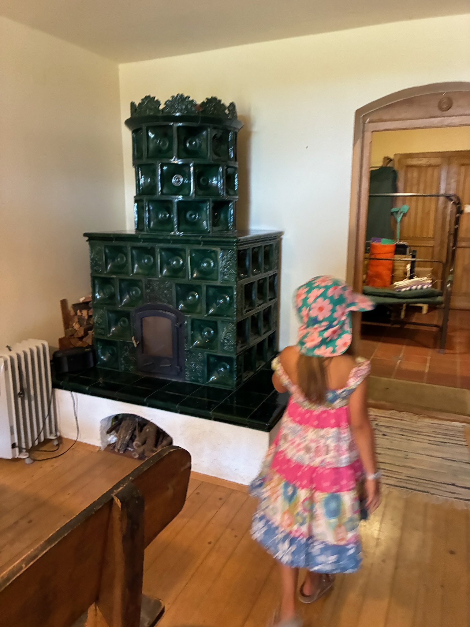The green tile stove — staying as the centrepiece