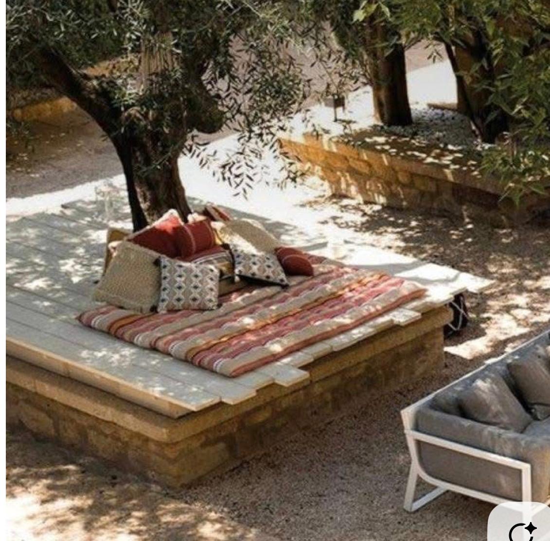 Stone platform daybed under an old tree