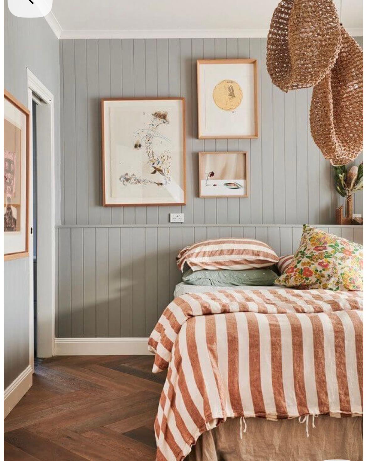 Sage panelled wall with striped linen bedding