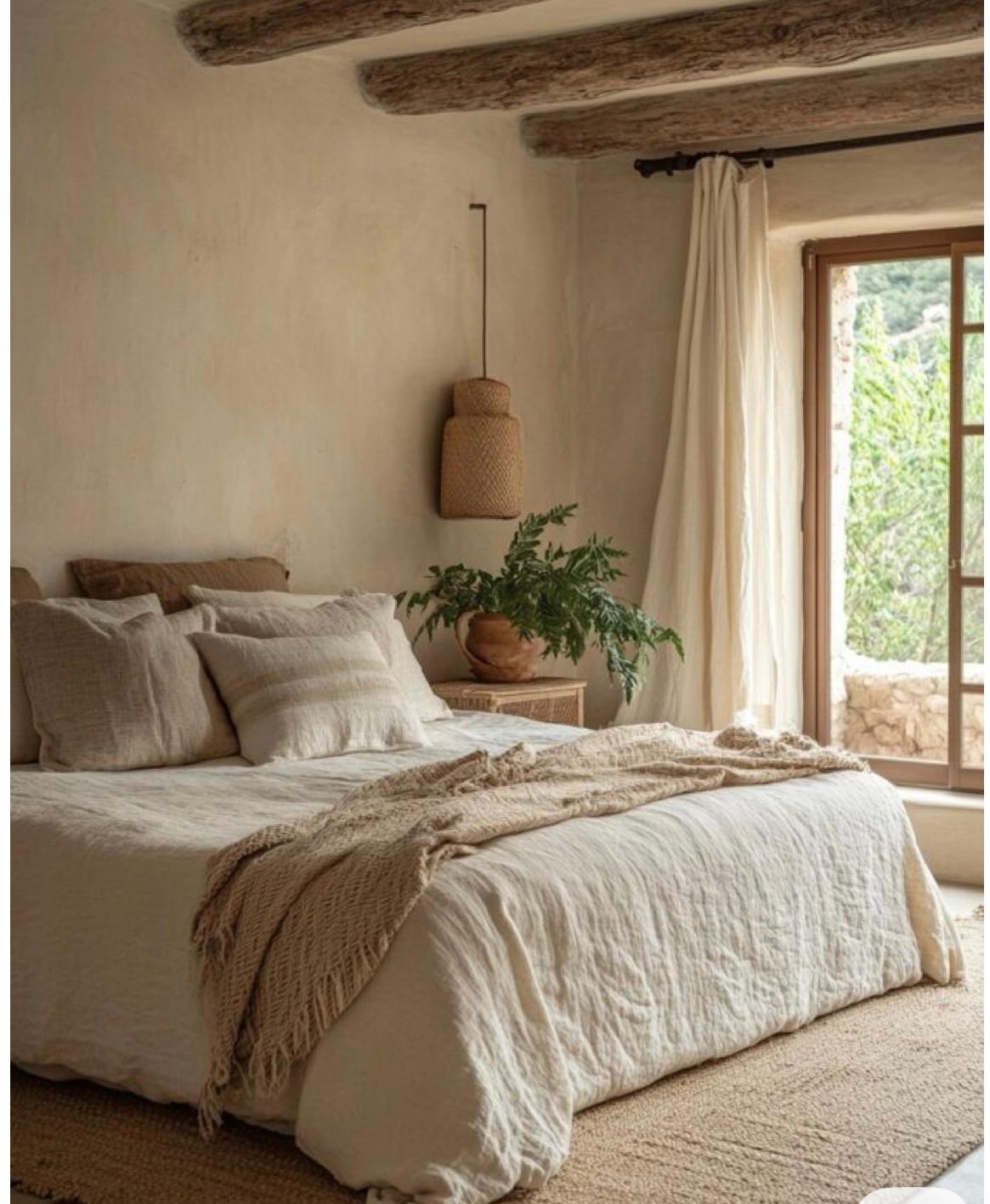 Linen bedding against plaster walls and exposed beams
