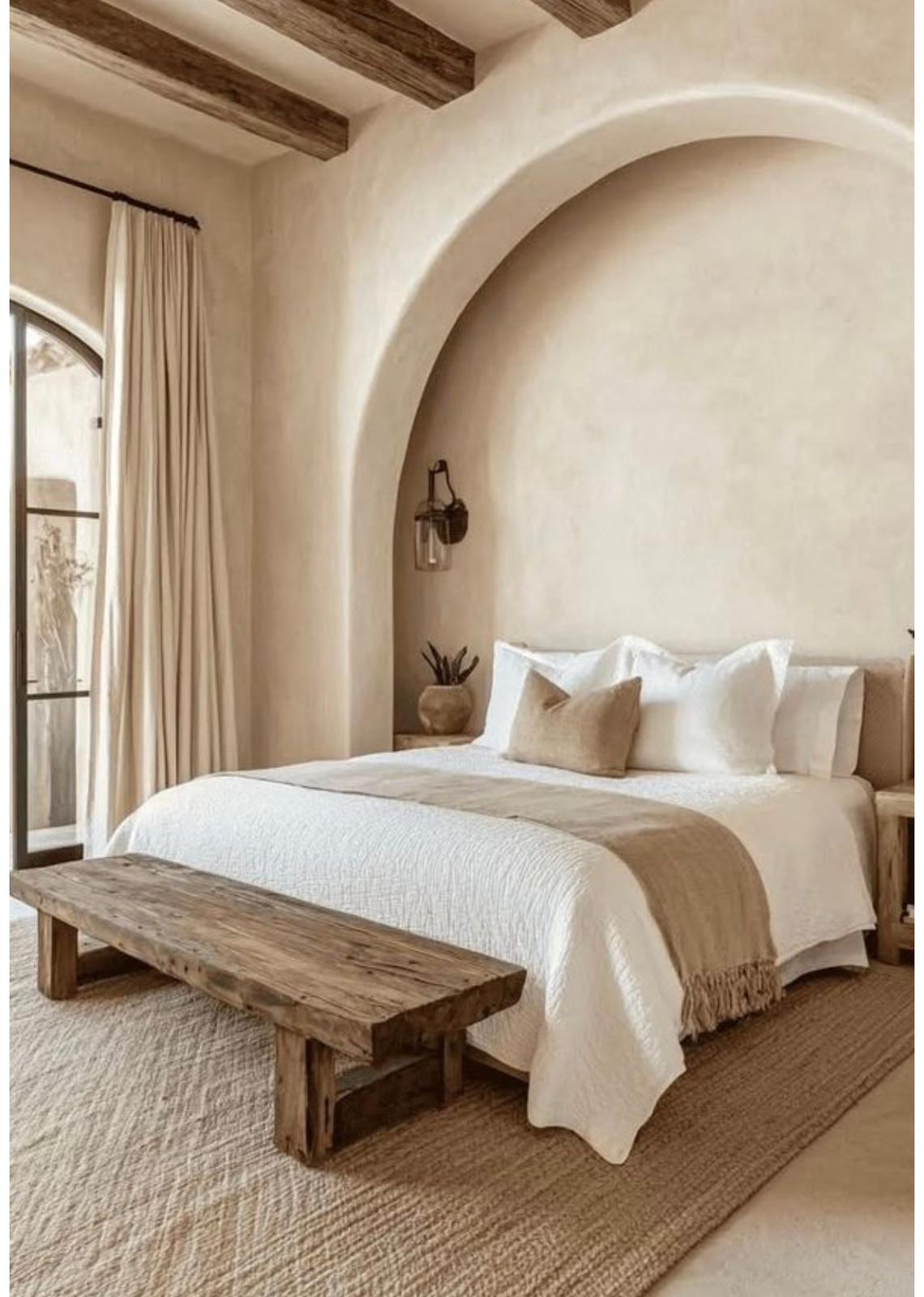 Plaster arch alcove framing the bed with a rustic bench