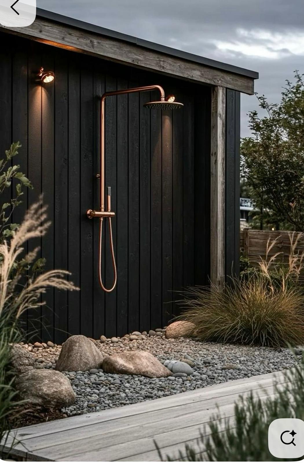 Black outdoor shower with copper rain fixture