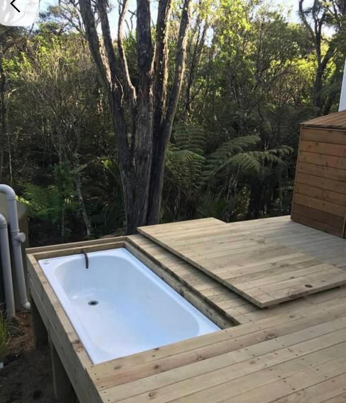 Built-in tub on wooden deck surrounded by forest